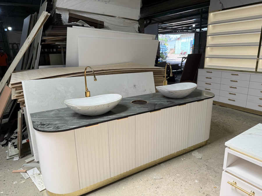 Hand wash counter in white fluted panelling with two ceramic basins and gold taps